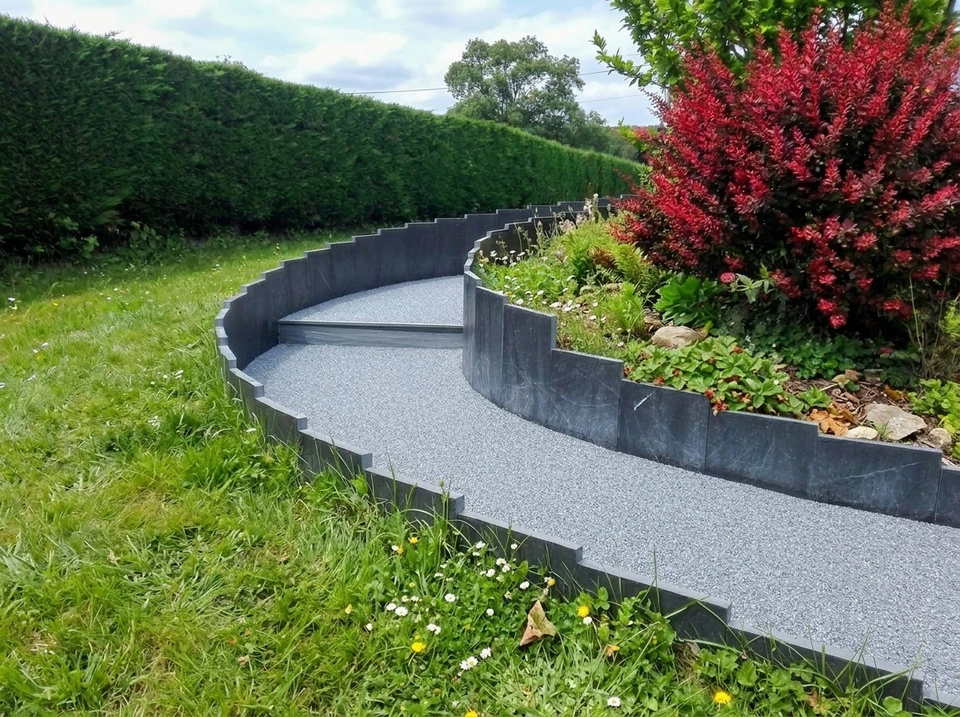Escalier courbe extérieur en pierre naturelle ardoise gris anthracite, intégré dans un jardin paysager