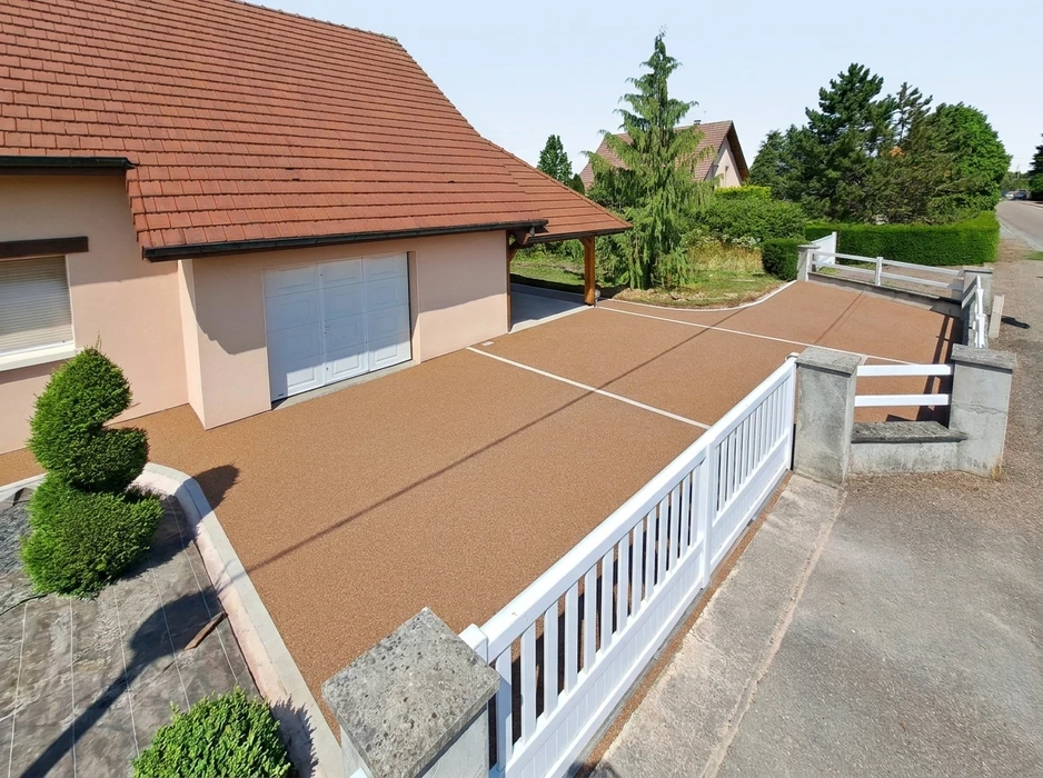 Allée de garage en résine drainante couleur sable/ocre, vue aérienne légèrement en plongée
