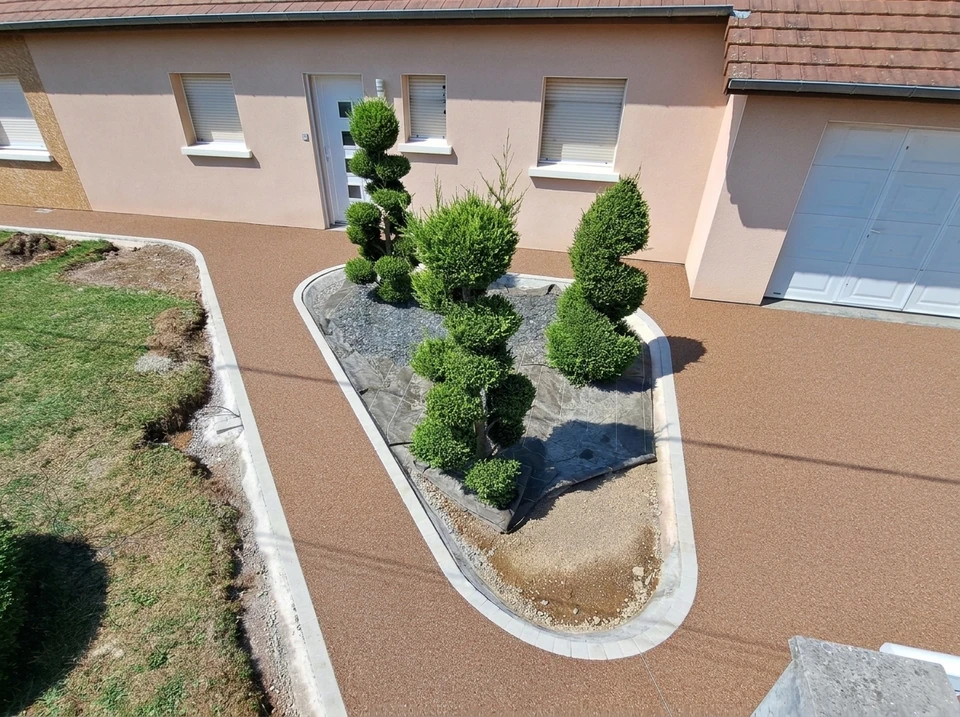 Allée de maison en résine drainante couleur terracotta, posée sur une large surface plane