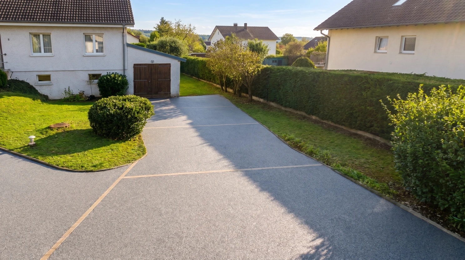 Garage résidentiel moderne avec porte sectionnelle blanche fermée et sol carrelé gris anthracite